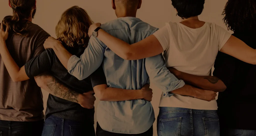 Team members standing together with their arms around one another, representing collaboration, inclusion, and workplace culture at Strat Property Management.